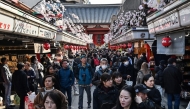 People walk along the main shopping street at Sensoji Temple in the popular tourist destination of Asakusa in central Tokyo on February 21, 2025. Photo by Richard A. Brooks / AFP