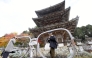 A large pair of glasses frames is seen in front of the three-story pagoda at Tsubosakadera temple in Takatori, Nara Prefecture. MUST CREDIT: The Japan News