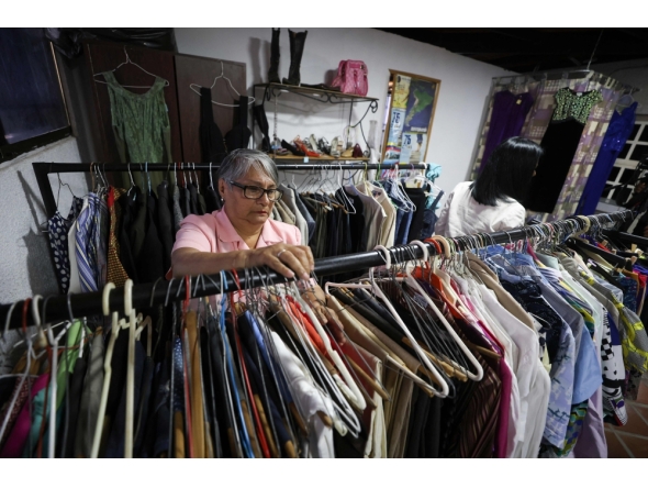 A teacher browses clothes inside a second-hand run by the Venezuelan Teachers' Federation (FVM) in Caracas, on February 17, 2025. (Photo by Pedro Mattey / AFP)
 