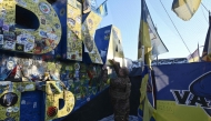 A Ukrainian serviceman leaves a message as he visits the sign indicating the entrance to the Donetsk region, covered by Ukrainian brigades flags and covered with a net to protect it against damages and drones, on February 21, 2025, amid the Russian invasion of Ukraine. (Photo by Genya SAVILOV / AFP)
 