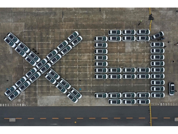 An aerial photo shows X9 electric vehicles by Chinese EV manufacturer XPeng, waiting to be loaded on a ship of the NYK line for Thailand during a ceremony in the Port of Guangzhou, China's southern Guangdong province on February 22, 2025. (Photo by Pedro Pardo / AFP)