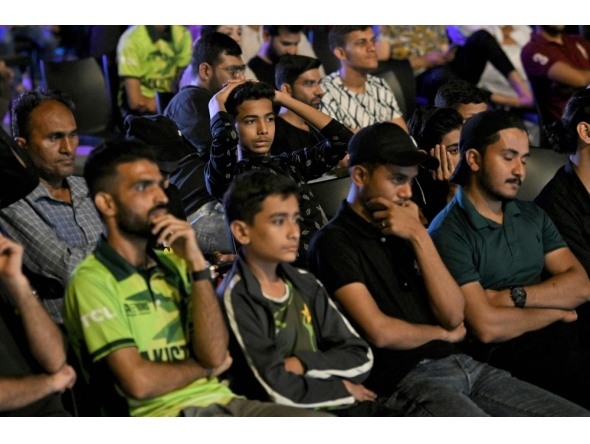 Pakistani cricket fans react as they watch a live broadcast of the ICC Champions Trophy one-day international (ODI) cricket match between India and Pakistan in Dubai, on a big screen in Karachi on February 23, 2025. (Photo by Asif Hassan / AFP)