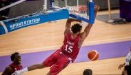 Qatar's Donte Grantham Mustafa Ndaw dunks the ball during the match.