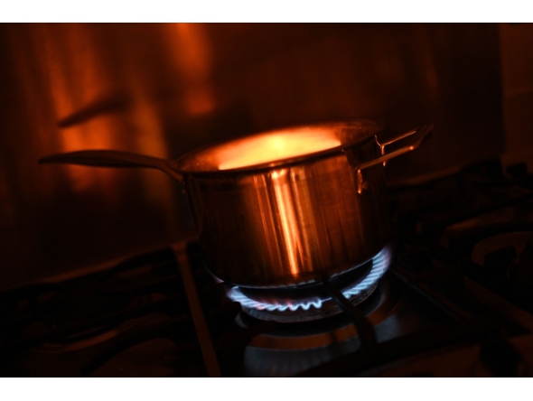 In this arranged photograph a pan is pictured on a gas hob in the kitchen of a residential property in Guildford, south of London on August 21, 2024. Photo by Justin TALLIS / AFP