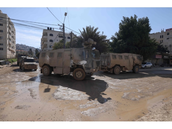 Vehicles of Israeli occupation forces drive down a road amid a weeks-long offensive at the Jenin refugee camp in the occupied West Bank on February 25, 2025. (Photo by Jaafar ASHTIYEH / AFP)
