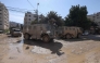 Vehicles of Israeli occupation forces drive down a road amid a weeks-long offensive at the Jenin refugee camp in the occupied West Bank on February 25, 2025. (Photo by Jaafar ASHTIYEH / AFP)
