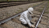 An Employee of ViaMobilidade - a company that manages subway and train lines in the Sao Paulo metropolitan area - takes the temperature of railway tracks in Osasco, Sao Paulo state, Brazil on February 24, 2025. (Photo by Nelson ALMEIDA / AFP)
