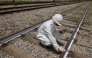 An Employee of ViaMobilidade - a company that manages subway and train lines in the Sao Paulo metropolitan area - takes the temperature of railway tracks in Osasco, Sao Paulo state, Brazil on February 24, 2025. (Photo by Nelson ALMEIDA / AFP)
