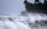 People watch as waves lash against the shore in Saint-Denis de la Reunion, on the French overseas territory island of La Reunion, as the tropical cyclone 