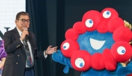 Japan's Prime Minister Shigeru Ishiba stands with Myaku-Myaku, the mascot for the 2025 Osaka World Expo, during a visit to the Tokyo Girls Collection fashion event in the Shibuya district of Tokyo on March 1, 2025. (Photo by Jiji Press / AFP)