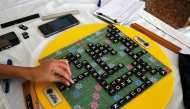 In this photograph taken on February 16, 2025, Pakistani prodigy Bilal Asher, world under-14 Scrabble champion, competes against professional Scrabble coach Waseem Khatri during an event in Karachi. (Photo by Asif Hassan / AFP) 