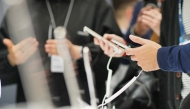 Attendees check out  mobile phones during the MWC (Mobile World Congress), the world's biggest mobile fair, in Barcelona on March 3, 2025. (Photo by Manaure Quintero / AFP)
