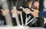 Attendees check out  mobile phones during the MWC (Mobile World Congress), the world's biggest mobile fair, in Barcelona on March 3, 2025. (Photo by Manaure Quintero / AFP)
