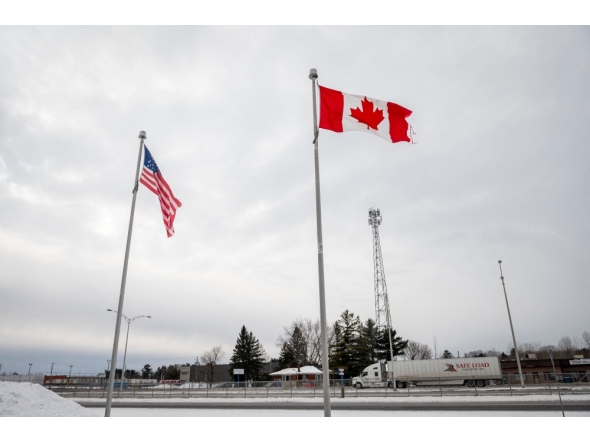 (Files) The Canadian and US flags fly near the Canada-US border in Blackpool, Quebec, Canada, on February 2, 2025.  (Photo by Andrej Ivanov / AFP)