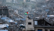 A Palestinian flag flutters amid the ruins of buildings in Beit Lahia in the northern Gaza Strip on March 4, 2025. (Photo by Bashar Taleb / AFP)