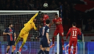 Liverpool's Brazilian goalkeeper #01 Alisson (2L) punches the ball as he makes a save during the UEFA Champions League Round of 16 first leg football match between Paris Saint-Germain (FRA) and Liverpool (ENG) at the Parc des Princes stadium in Paris on March 5, 2025. (Photo by Anne-Christine POUJOULAT / AFP)
