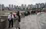 People look at the skyline next to the Jialing river in Yuzhong District in Chongqing in southwestern China on March 6, 2025. (Photo by Hector RETAMAL / AFP)