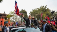 Nepal's former King Gyanendra Bir Bikram Shah Dev waves as he arrives at Tribhuwan International Airport in Kathmandu on March 9, 2025. (Photo by Prakash Mathema / AFP)