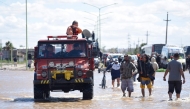 People is transported on a police boat through flooded waters the day after a heavy storm in Bahia Blanca, 600 km south of Buenos Aires on March 8, 2025. At least ten people died and more than 1,000 were evacuated in the Argentine port city of Bahia Blanca as torrential rains flooded homes and hospitals, destroyed roads and forced authorities to cut the power. (Photo by PABLO PRESTI / AFP)
