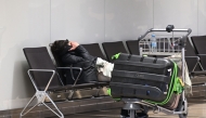 A passenger sleeps at the empty Berlin-Brandenburg Airport's Terminal during a strike of German union Verdi at the Berlin-Brandenburg Airport (BER) in Schoenefeld, southeast of Berlin, on March 10, 2025. (Photo by Ralf Hirschberger / AFP)