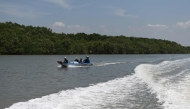 This photo taken on April 21, 2022 shows oyster farmers riding their boat past a mangrove forest at a coastal area in Ho Chi Minh City's Can Gio district. Photo by Nhac NGUYEN / AFP