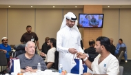 A QNB official distributing gift to a patient during the Ramadan Iftar.