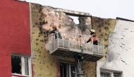 Specialists work on the facade of a damaged apartment building following a drone attack in Moscow on March 11, 2025. (Photo by Tatyana Makeyeva / AFP)