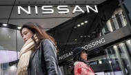 This picture taken on February 5, 2025 shows pedestrians walking past a showroom for Japanese automaker Nissan in Tokyo. Photo by Yuichi YAMAZAKI / AFP