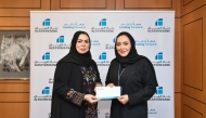 General Manager, Personal Banking, Rana Al Asaad (right) presenting the support to QCS General Manager, Mona Ashkanani.