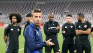 Qatar head coach Luis Garcia speaks to players during a training session.