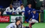 Los Angeles Dodgers' Shohei Ohtani (C), Teoscar Hernandez (L) and Roki Sasaki (R) watch from the dugout during the exhibition baseball game between the Los Angeles Dodgers and Hanshin Tigers at the Tokyo Dome in Tokyo on March 16, 2025. (Photo by Yuichi Yamazaki / AFP) 