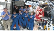 This screengrab made from a NASA livestream shows the SpaceX Dragon Crew-10 members (C, in dark blue) NASA astronauts Anne McClain and Nichole Ayers, JAXA (Japan Aerospace Exploration Agency) astronaut Takuya Onishi, and Roscosmos cosmonaut Kirill Peskov, clapping after entering the International Space Station flanked by NASA astronauts Butch Wilmore, Suni Williams, Nick Hague and Don Pettit and Russian cosmonauts Aleksandr Gorbunov, Alexey Ochinin and Ivan Vagner, on March 16, 2025. (Photo by NASA / AFP)