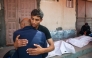 Relatives mourn by the bodies of three Palestinian men killed in an Israeli drone strike east of the Bureij camp, at the al-Aqsa Martyrs hospital in Deir el-Balah in the central Gaza Strip on March 17, 2025. (Photo by Eyad Baba / AFP)