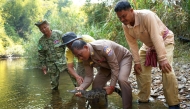 This handout photo taken on March 2, 2025 and released on March 18 by conservation group Fauna and Flora shows government officials preparing to release a Siamese crocodile in the water in Virachey National Park at Ta Veng district in Ratanakiri province. (Photo by Pablo Sinovas / Fauna and Flora / AFP)