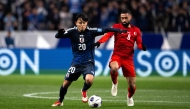 Japan's Takefusa Kubo (L) and Bahrain's Mohamed Marhoon compete for the ball during the 2026 FIFA World Cup Asian qualification football match between Japan and Bahrain in Saitama on March 20, 2025. (Photo by Philip FONG / AFP)