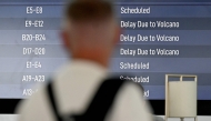 Passengers look at an electronic board displaying cancelled flights at the Ngurah Rai International Airport in Tuban near Denpasar on Indonesia's resort island of Bali on March 21, 2025, after Mount Lewotobi Laki-Laki volcano in the archipelago nation's east erupted, shooting dark ash eight kilometres into the sky. (Photo by SONNY TUMBELAKA / AFP)