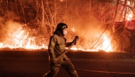 A firefighter prepares to spray water as wildfires spread along the slopes in Uiseong, South Korea, on March 24, 2025. Photo by YASUYOSHI CHIBA / AFP.