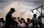 Tourists pose for photographs in front of the Sydney Opera House and Sydney Harbour Bridge on March 31, 2025. Photo by DAVID GRAY / AFP