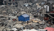 People stand outside their tent set up on the rubble of a destroyed building at the Jabalia camp for displaced Palestinians in the northern Gaza Strip on April 8, 2025. Photo by Bashar TALEB / AFP