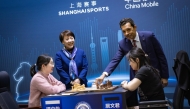 QCA President Mohammed Al Mudahka makes the opening move for match between China's Ju Wenjun and Tan Zhongyi.  