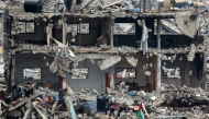 A Palestinian flag flutters as children play amid the rubble of a destroyed building at the Jabalia camp for displaced Palestinians in the northern Gaza Strip on April 8, 2025. Photo by Bashar TALEB / AFP