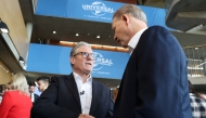 Britain's Prime Minister Keir Starmer (L) shakes hands with Comcast Corporation President Michael Cavanagh, on the day of an announcement that US media giant Comcast Corp will build its first Universal theme park and resort in Europe, set to open in 2031, during a visit to Bedford, north of London, on April 9, 2025. Photo by John Sibley / POOL / AFP