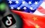 A photo taken on April 10, 2025 shows the Chinese social networking service TikTok's logo on a smartphone screen and US' and China flags combo illustration on a laptop screen in Frankfurt am Main, western Germany. (Photo by Kirill Kudryavtsev / AFP)
