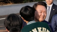 Ousted South Korean president Yoon Suk Yeol is greeted by a college student before leaving the presidential residence in Seoul on April 11, 2025. (Photo by Ahn Young-joon / POOL / AFP)