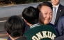 Ousted South Korean president Yoon Suk Yeol is greeted by a college student before leaving the presidential residence in Seoul on April 11, 2025. (Photo by Ahn Young-joon / POOL / AFP)