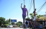 People walk past a giant cardboard image of Ecuador's President Daniel Noboa in Olon, Santa Elena province, Ecuador, on April 14, 2025, the day after the presidential runoff election.  (Photo by Raul Arboleda / AFP)