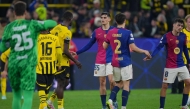 Players including Barcelona's Spanish defender #35 Gerard Martin (C) react after the UEFA Champions League quarter-final second leg football match between BVB Borussia Dortmund and FC Barcelona in Dortmund, western Germany on April 15, 2025. (Photo by Pau BARRENA / AFP)
