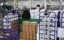 Stacked parcels are seen up front as a Hongkong Post employee stands at a service counter at a post office in Hong Kong on April 16, 2025. (Photo by Peter Parks / AFP)