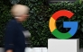 (Files) A woman walks past a Google logo at the Google Campus in Warsaw on February 13, 2025. (Photo by Sergei Gapon / AFP)