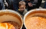 A Palestinian child waits to receive his portion of food a distribution point at the Nuseirat refugee camp in the central Gaza Strip on April 12, 2025. Photo by Eyad BABA / AFP.
